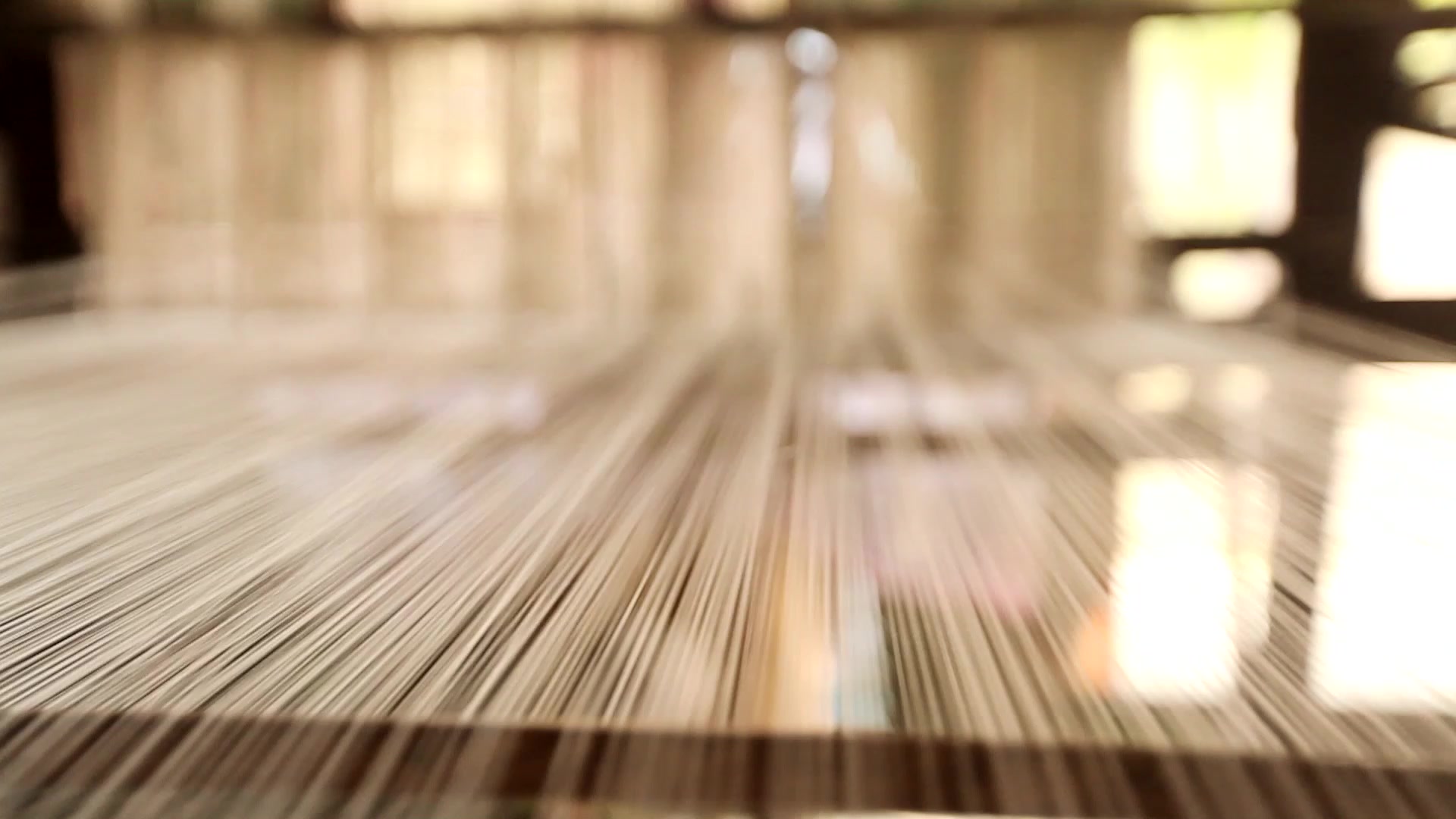 A close view along fine warp threads stretched on a handloom