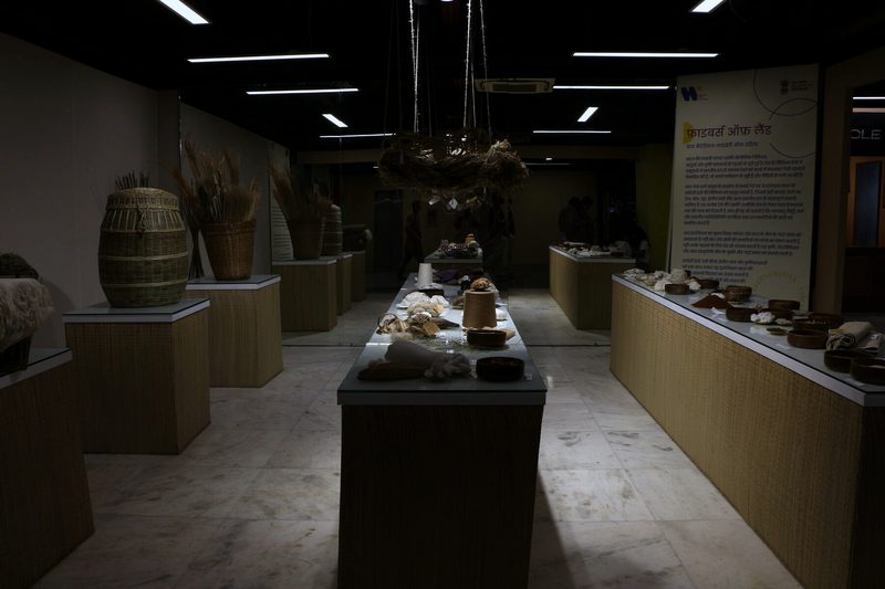 Interior museum display showing woven baskets, loom artifacts, and informational panels.